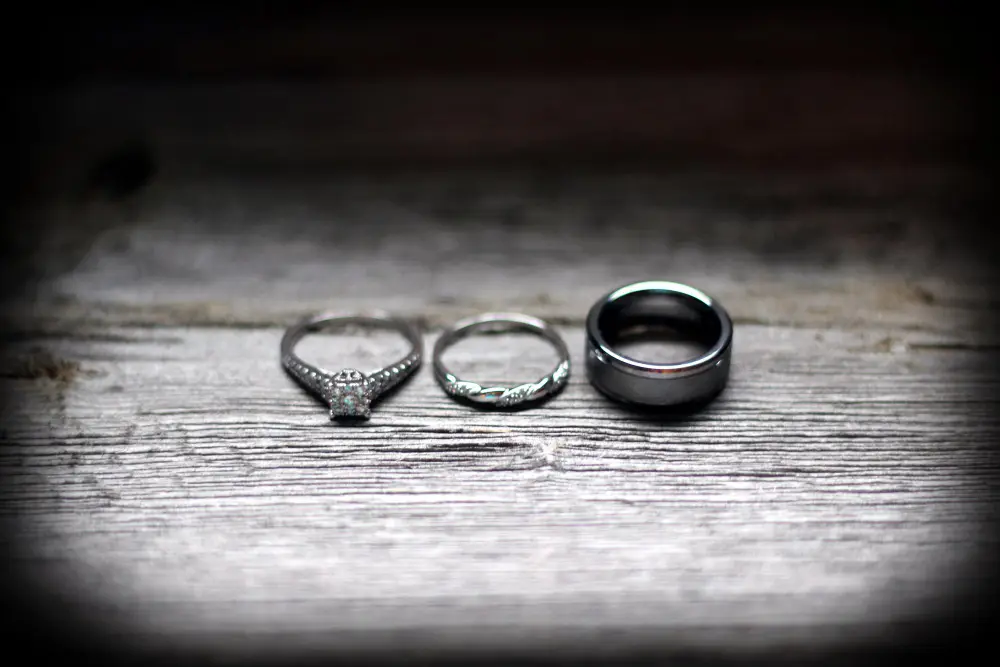 close up three wedding rings wooden table