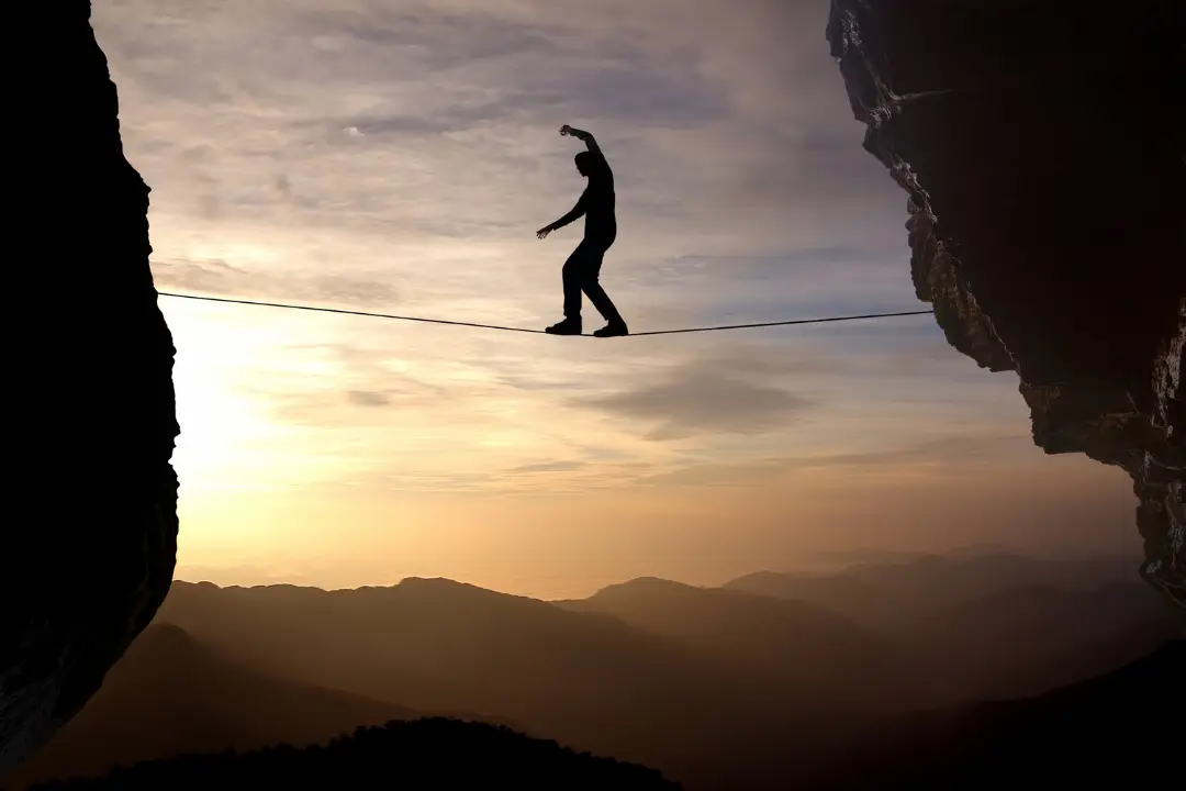 silhouette of person on tightrope sunset 