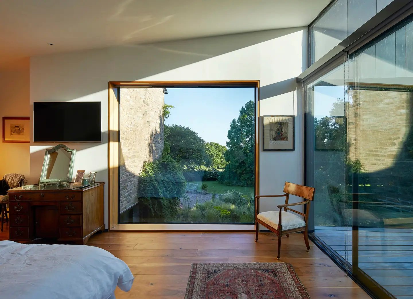Bedroom with a large picture window onto a garden