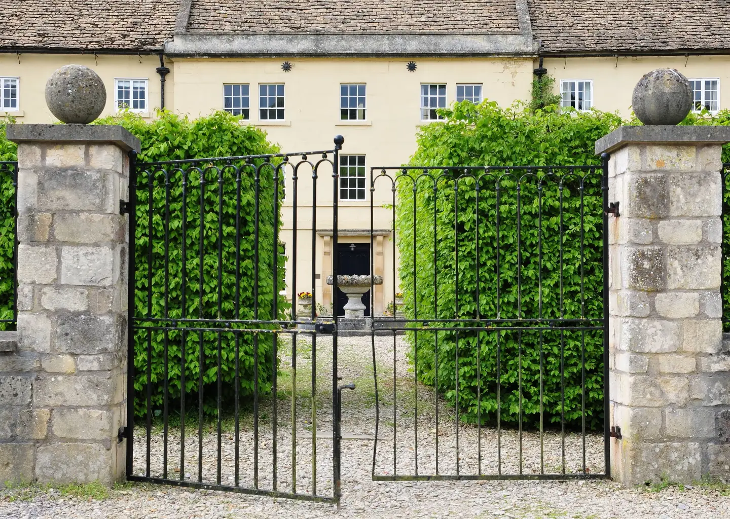 Iron gates opening onto a country house