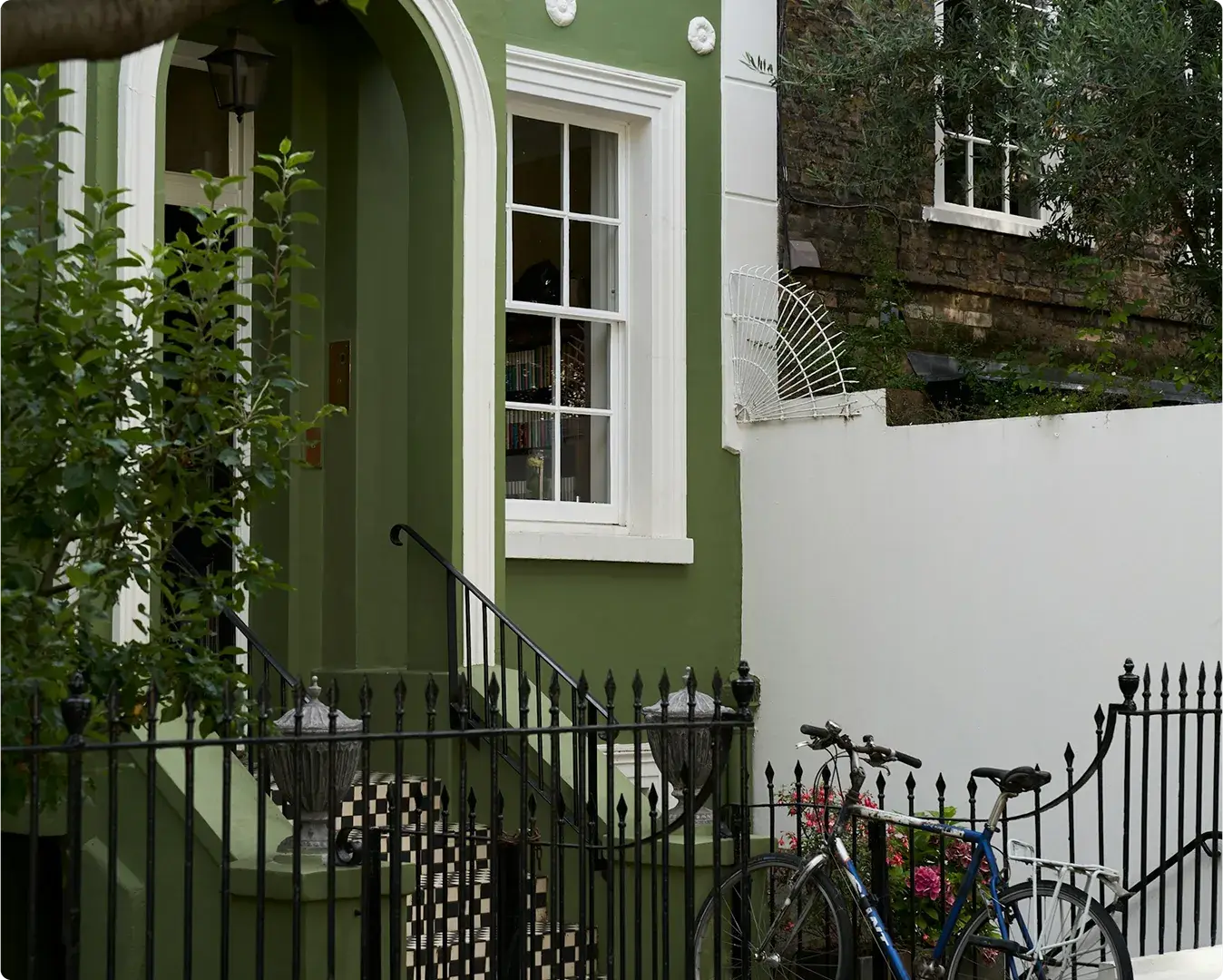 Green-painted townhouse with iron railings