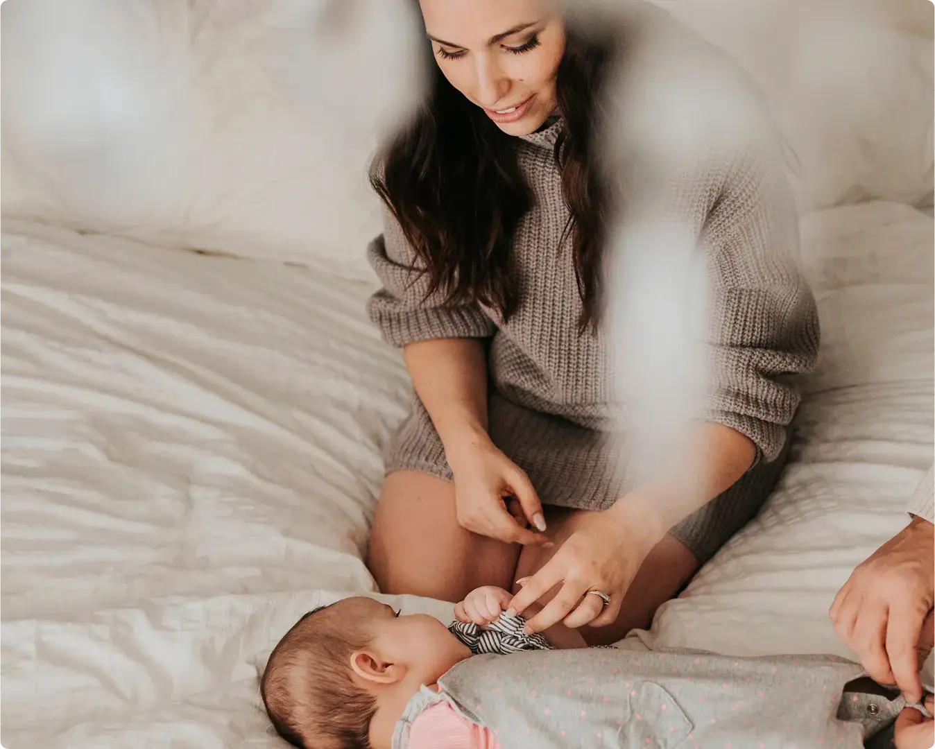 Parent with a baby on a bed